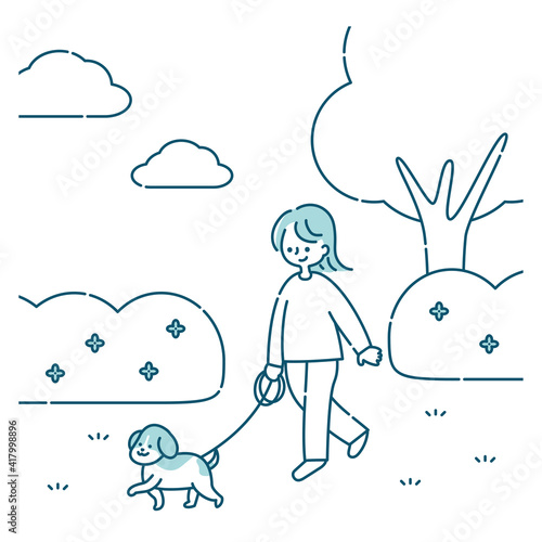 犬と公園を散歩する女性