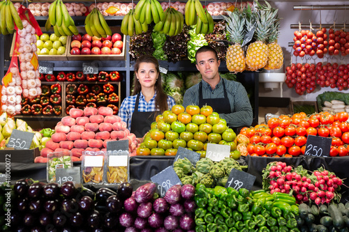 Cheerful male and female shop assistants in vegetable shop