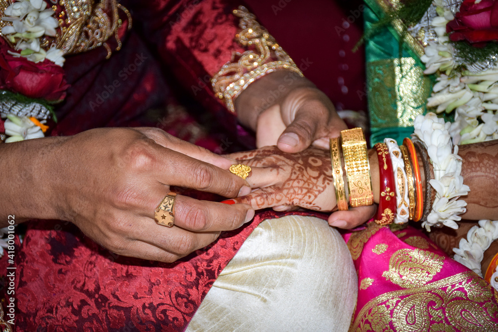 The groom wearing the bride a wedding ring on her finger