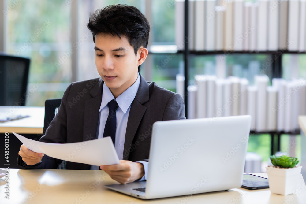 Young Asian manager doing paperwork in office Young Asian manager doing paperwork in office