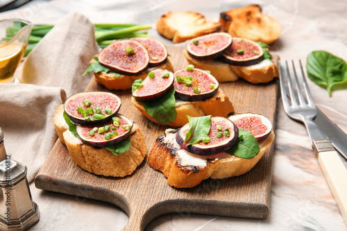 Wooden board with fresh tasty bruschettas on grunge background