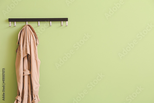 Hanger with coat on color background photo
