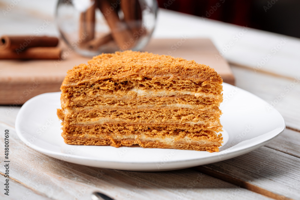 Closeup on slice of sweet honey cake on the wooden table Closeup on slice of sweet honey cake on the wooden table