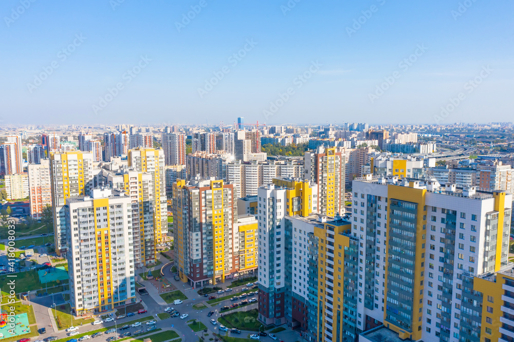 Fototapeta premium Panoramic aerial view of the city with multi-storey residential buildings and highways.