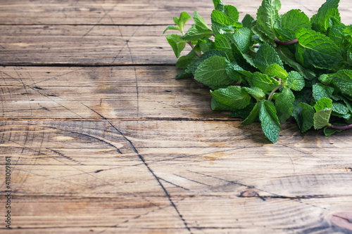 Foto Fresh sprigs of fragrant mint on a wooden background with copy space