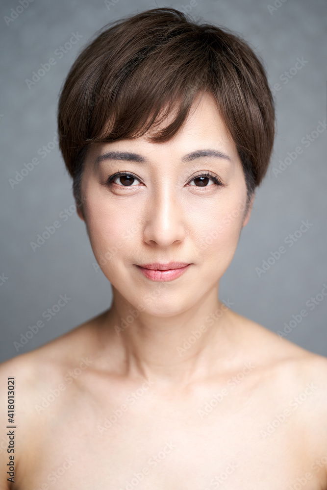 カメラ目線でほほ笑む中年の日本人女性 カメラ目線でほほ笑む中年の日本人女性