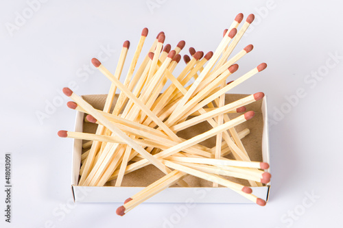 matches on white background. Large matches are randomly scattered on the matchbox.