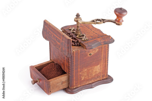 Old wooden coffee grinder with coffee beans.