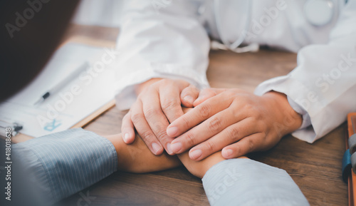 Close-up of the psychiatrist's hand holding the patient's hand. To encourage and comfort the patient