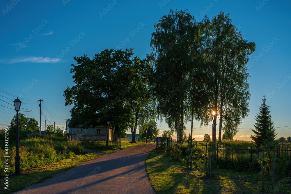 Magnificent nature, Russian birch trees surround the entrance to the monastery in the rays of the setting sun. Holy Trinity Alexander Svirsky Monastery in the Leningrad region. Magnificent nature, Russian birch trees surround the entrance to the monastery in the rays of the setting sun. Holy Trinity Alexander Svirsky Monastery in the Leningrad region.