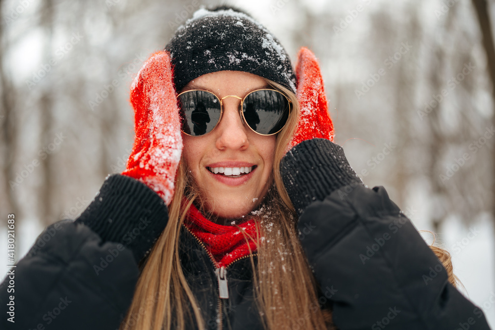 Happy smiling young woman having fun with snow in a winter park Happy smiling young woman having fun with snow in a winter park