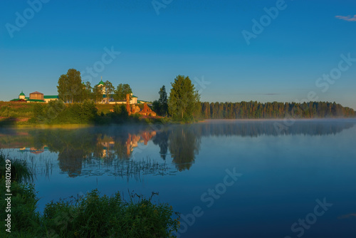 Pristine peace and quiet over the lake in the morning sunrise. Holy Trinity Alexander Svirsky Monastery in the Leningrad region, known for architectural monuments of the XVI and XVII centuries.