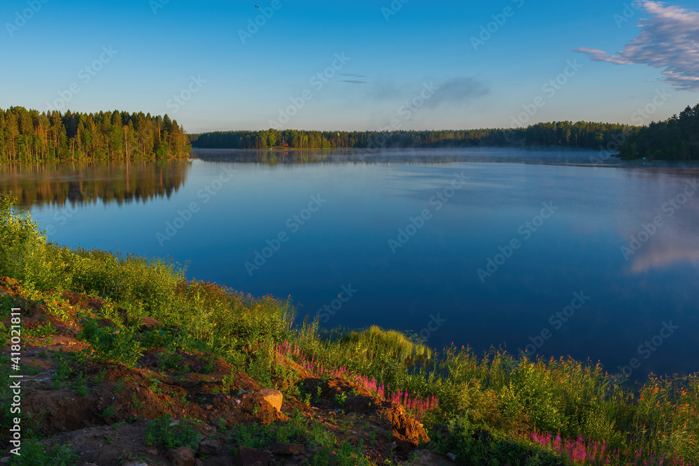 Picturesque places of the Roshchinsky lake near the walls of the monastery at sunrise. Holy Trinity Alexander Svirsky Monastery in the Leningrad region, known for architectural monuments.