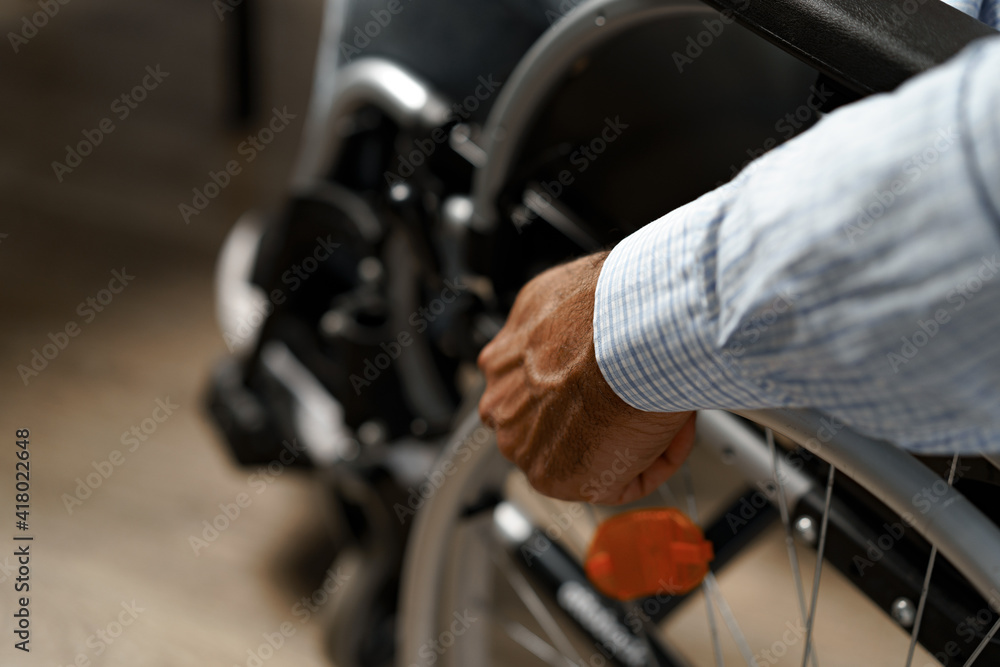 Unrecognizable disabled man sitting in a wheelchair Unrecognizable disabled man sitting in a wheelchair