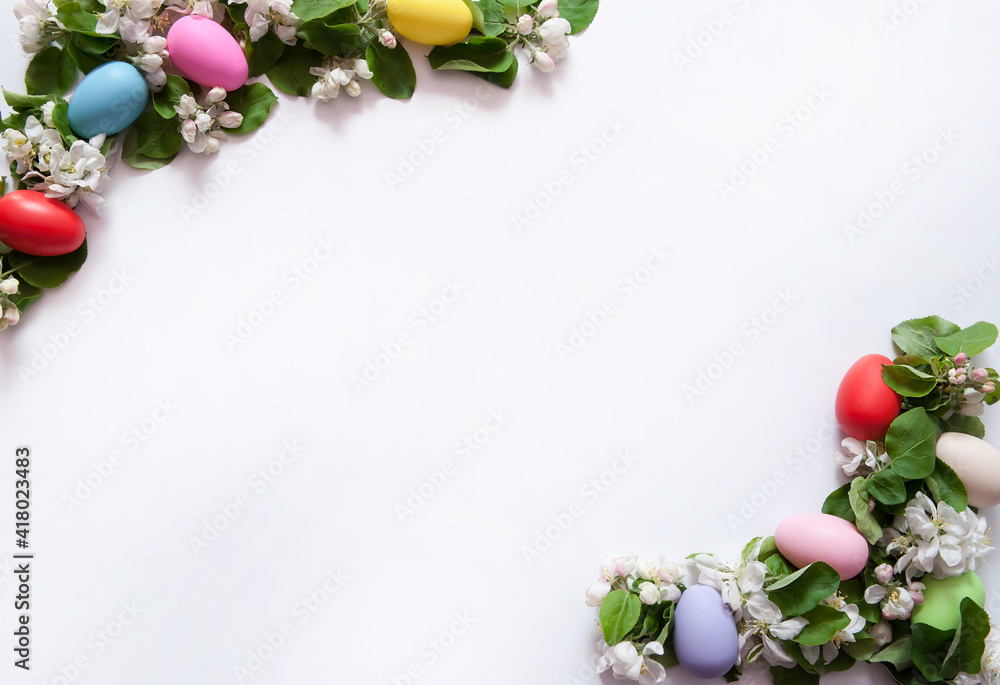 Easter composition. A frame of green leaves and pink-and-white apple blossoms and multicolored eggs on a white background. Happy Easter Holidays. Top view. Free space. Easter composition. A frame of green leaves and pink-and-white apple blossoms and multicolored eggs on a white background. Happy Easter Holidays. Top view. Free space.