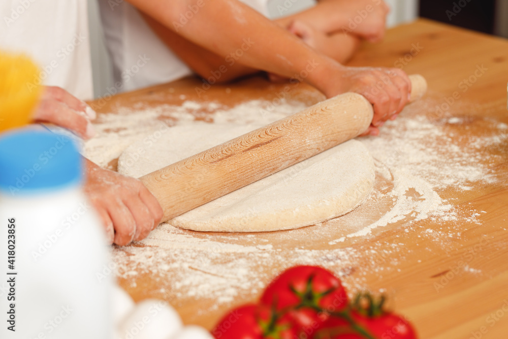 Close up of woman with her child kneading dough