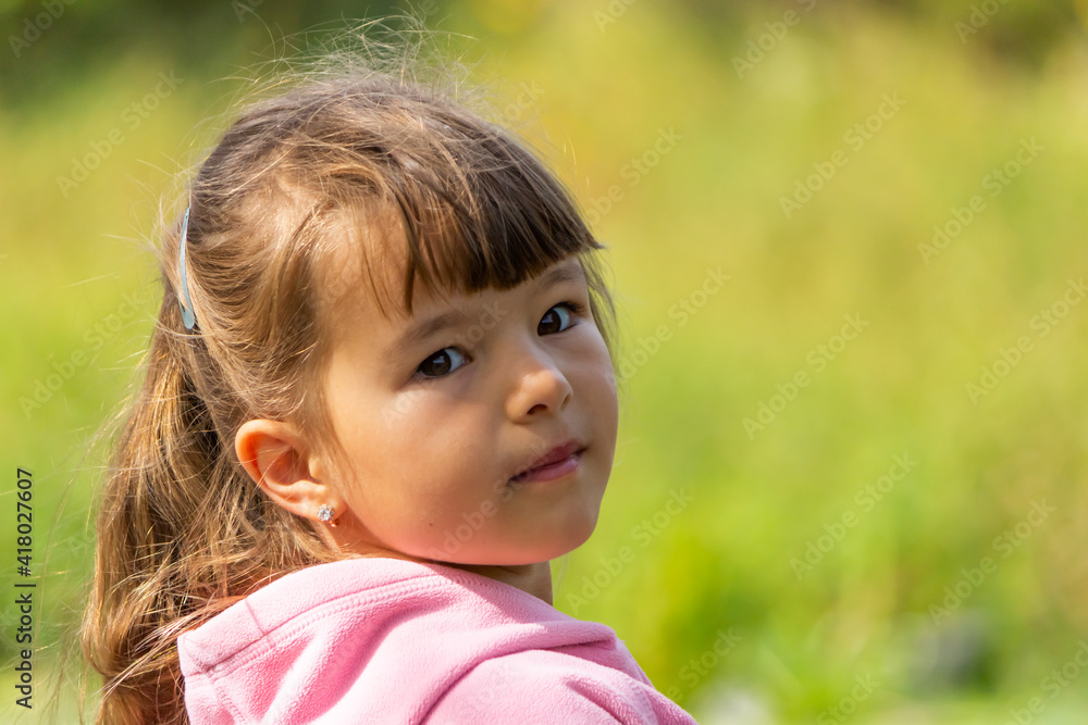 Beautiful little girl on a blurred green background Beautiful little girl on a blurred green background