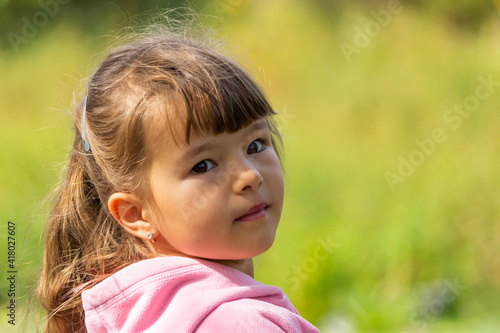 Beautiful little girl on a blurred green background