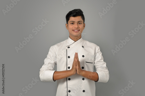 Fotografie Happy male indian chef in a greetting pose to Namaste hands, cooking, profession