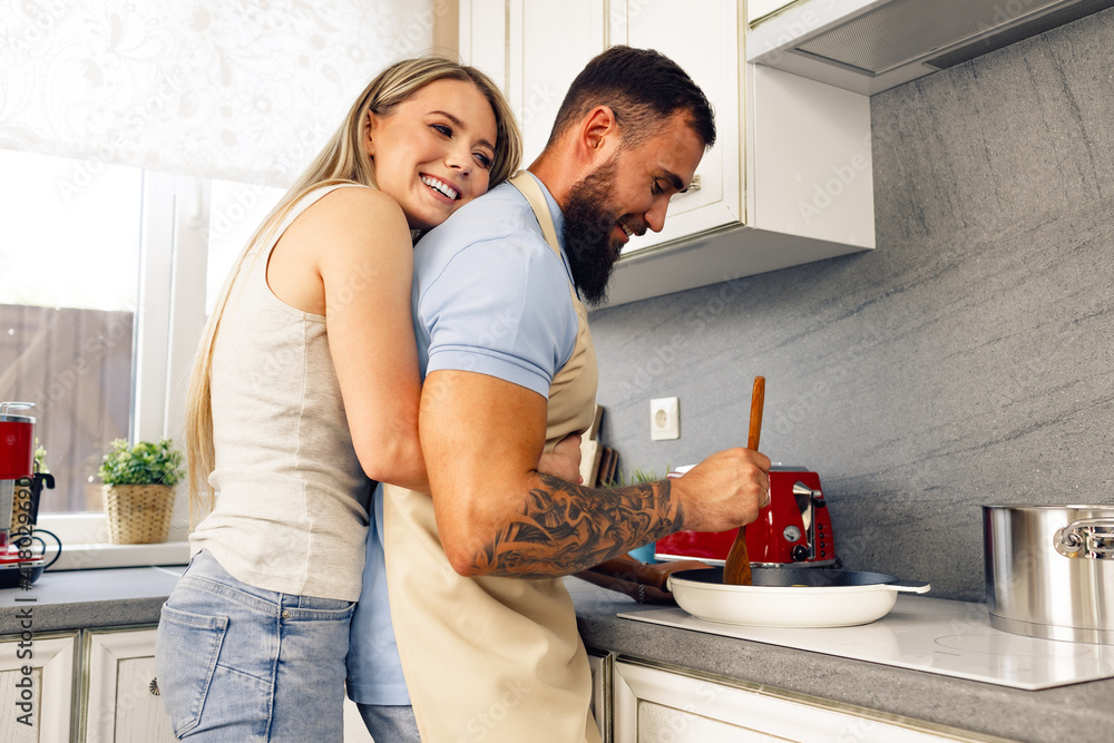 Young man and woman cooking food in kitchen together, happy couple preparing food Young man and woman cooking food in kitchen together, happy couple preparing food