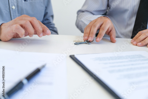 Sales manager giving advice application form document, considering mortgage loan offer for car and house insurance.