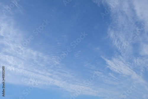 Bright blue sky with feathery clouds.