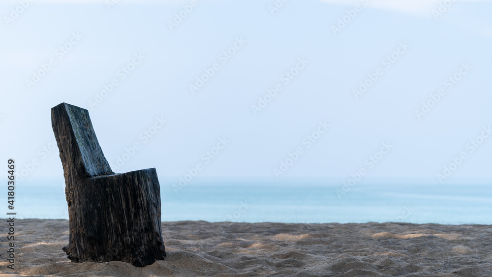 A timber chair stump on the sand beach by the sea. A timber chair stump on the sand beach by the sea.
