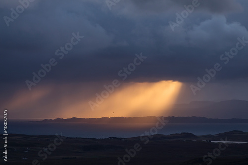 Rays of light at sunrise with cloudy and rainy weather. Scotland, UK.