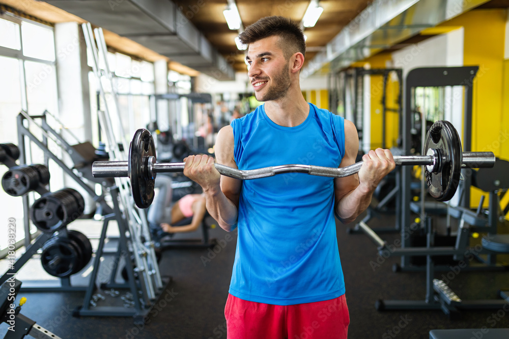 Sport, fitness, lifestyle and people concept. Happy fit man exercising with dumbbells in gym Sport, fitness, lifestyle and people concept. Happy fit man exercising with dumbbells in gym