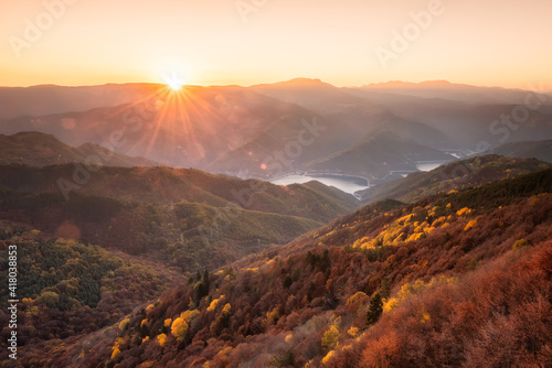 Beautiful panoramic skyline autumn view with colorful sunrise above an autumn forest in Rhodope Mountains, Bulgaria.