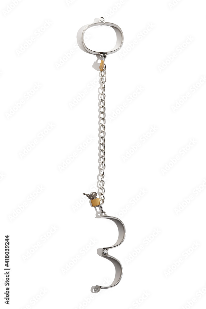 Detail shot of chrome steel wristbands with bronze padlocks and pair of keys. The iron shackles are connected by steel chain and isolated on the white background. Detail shot of chrome steel wristbands with bronze padlocks and pair of keys. The iron shackles are connected by steel chain and isolated on the white background.