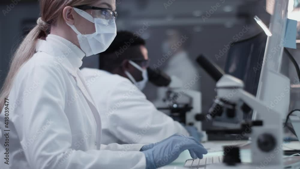 Diverse scientists studying medical samples and human skeleton. Using computers and microscopes. Modern laboratory interior Diverse scientists studying medical samples and human skeleton. Using computers and microscopes. Modern laboratory interior