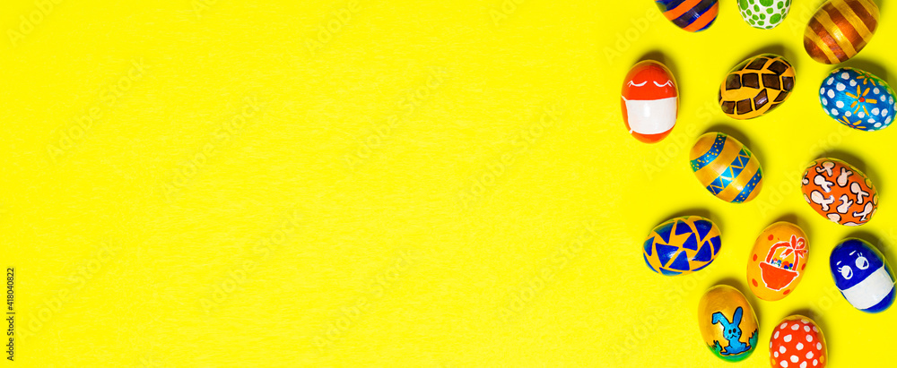 Multicolored Easter eggs on a yellow background. Eggs with faces put on protective masks against coronavirus during quarantine Multicolored Easter eggs on a yellow background. Eggs with faces put on protective masks against coronavirus during quarantine