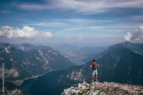 man with a backpack takes in Austrian nature and a hallstatter see from Mount Krippenstein. A sense of relaxation and freedom. The sporty type enjoys the feeling of victory over this mountain