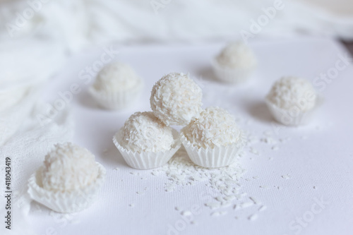 White chocolate covered chocolates sprinkled with coconut chips