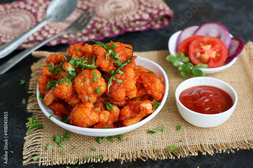 Gobi Manchurian dry, Gobi 65 with tomato sauce popular Indian street food snack Delhi Mumbai India made cauliflower florets Veg Manchurian chilly gobi Indo Chinese side dish chapati roti photo