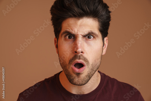 Displeased unshaven young man expressing surprise on camera © Drobot Dean