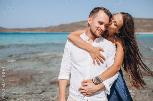 Portrait of a woman embracing her man from behind on seaside background