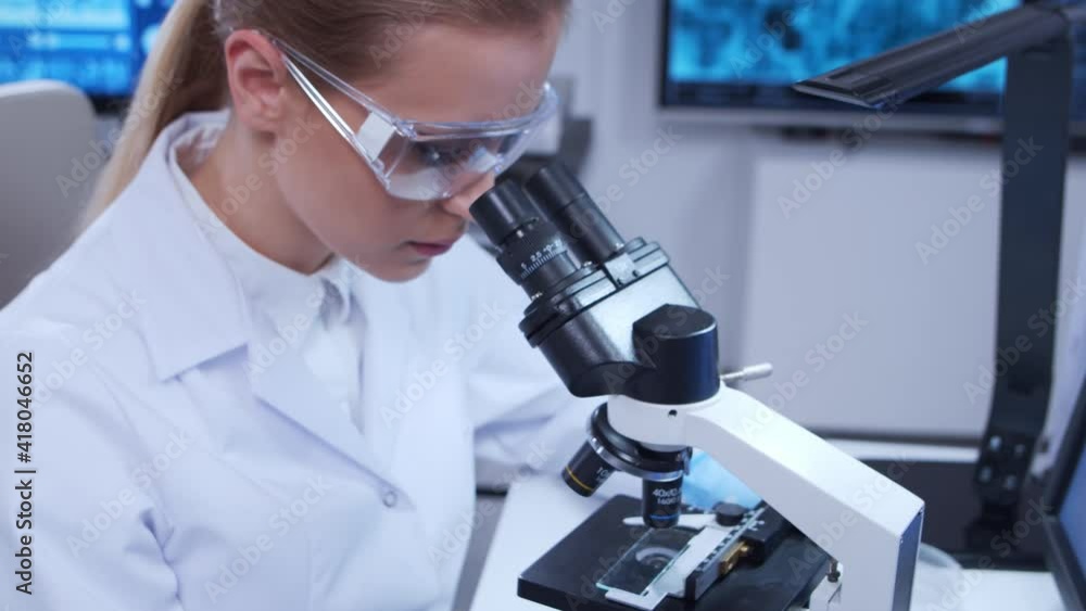 Elderly professor and young laboratory assistant are doing scientific experiment in a modern laboratory. Genetic engineers workplace. The concept of science, medicine and vaccine development. Elderly professor and young laboratory assistant are doing scientific experiment in a modern laboratory. Genetic engineers workplace. The concept of science, medicine and vaccine development.