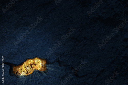 Golden bitcoins inside a rock cracked open. Mining bitcoin concept with copy space. photo