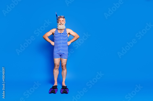 Full size photo of optimistic grey beard man wear fins mask blue swimsuit isolated on blue background © deagreez