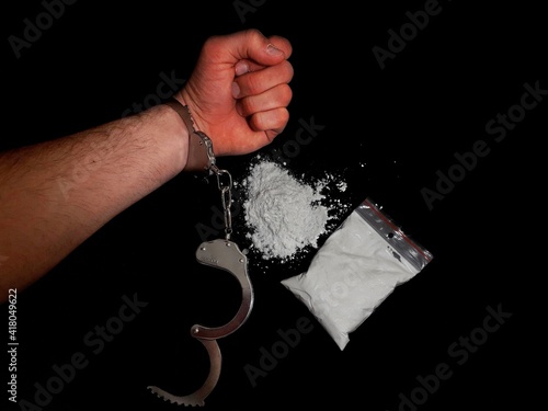 Handcuffed man and cocaine drug powder pile and bag, arrested drug dealer