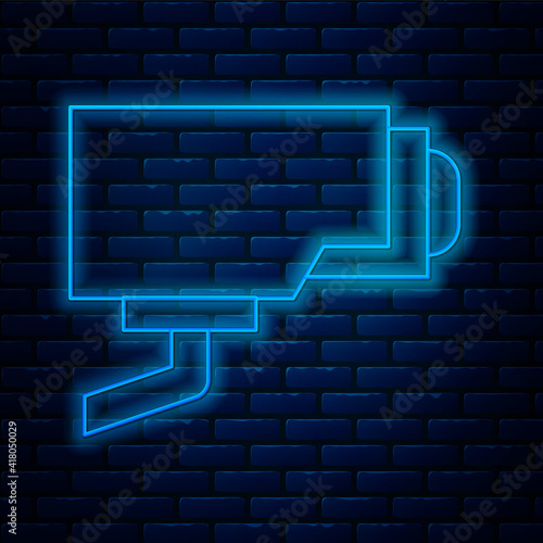 Glowing neon line Security camera icon isolated on brick wall background. Vector.
