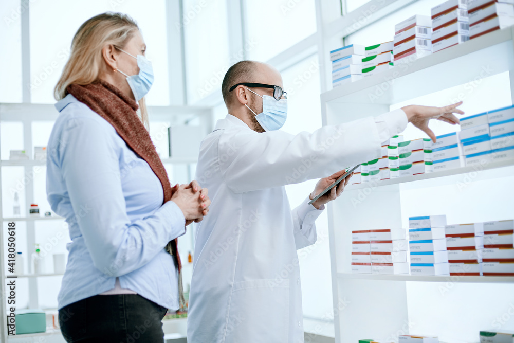 Fototapeta premium pharmacists in protective masks using a digital tablet .