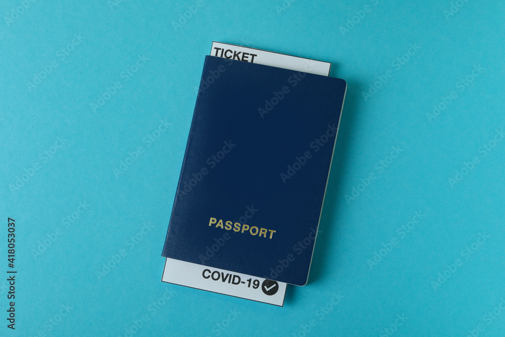 Passport with ticket and Covid - 19 mark on blue background Passport with ticket and Covid - 19 mark on blue background