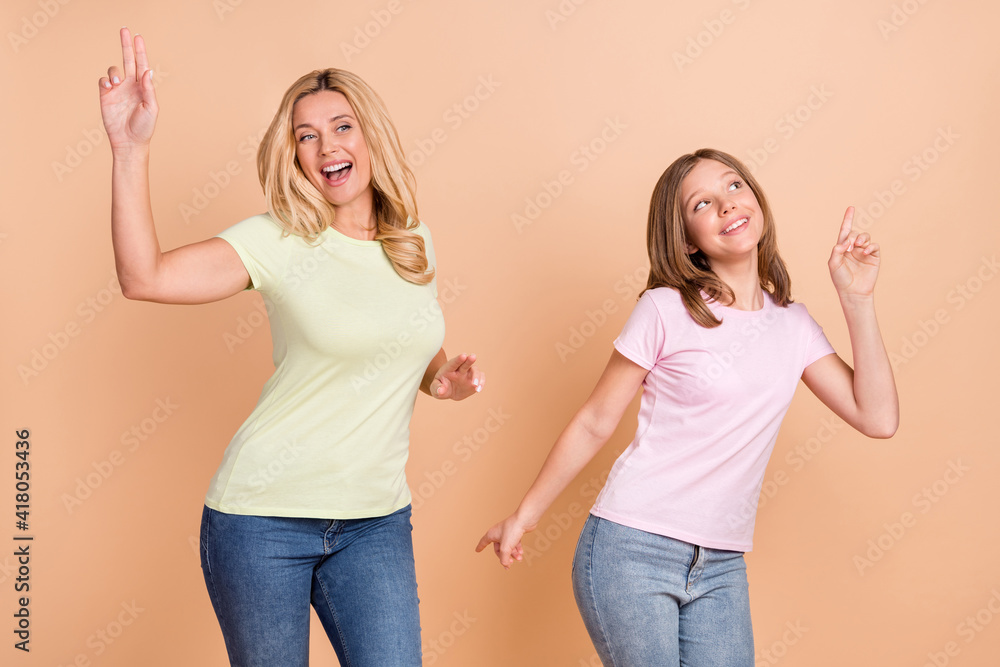 Photo of charming funny daughter mom dressed casual clothes dancing isolated beige color background Photo of charming funny daughter mom dressed casual clothes dancing isolated beige color background