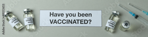 Text Have you been vaccinated, syringes and vials of Covid - 19 vaccine on gray background