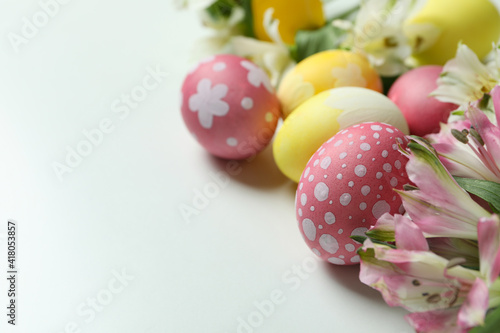 Color Easter eggs and alstroemeria flowers on white background © Atlas