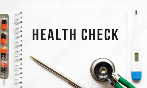 Wallpaper Mural HEALTH CHECK text written in a notebook lying on a desk and a stethoscope. Torontodigital.ca