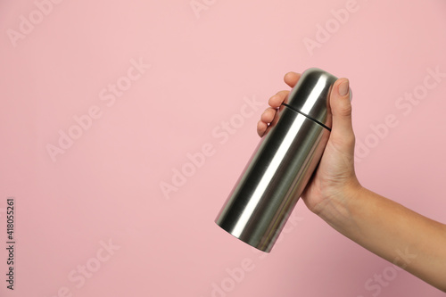 Woman holding modern thermos on pink background, closeup. Space for text